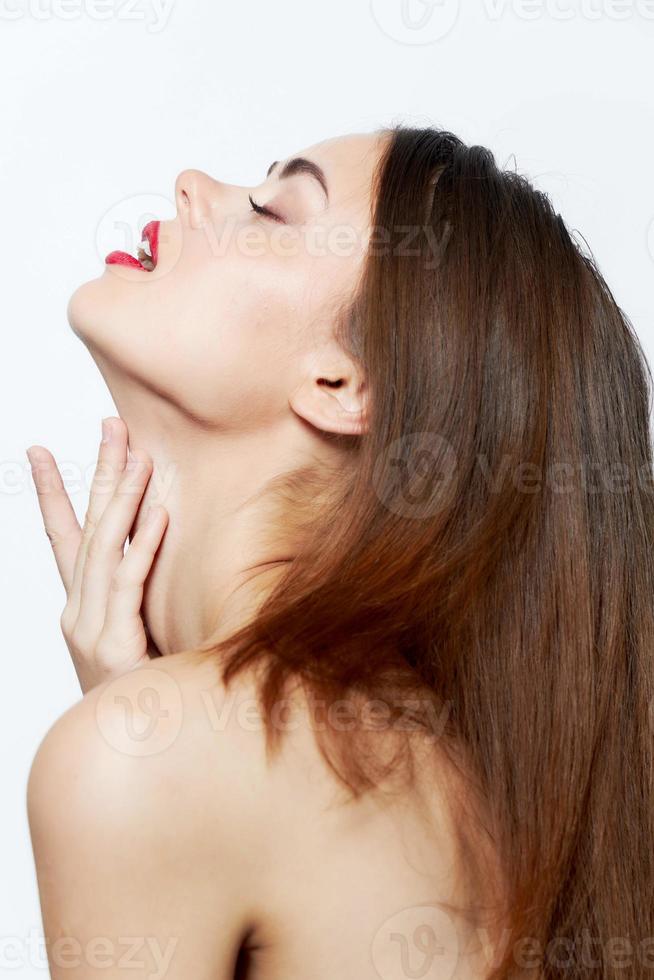sexy mujer inclinado su cabeza espalda y toques su cara con su manos lápiz labial foto