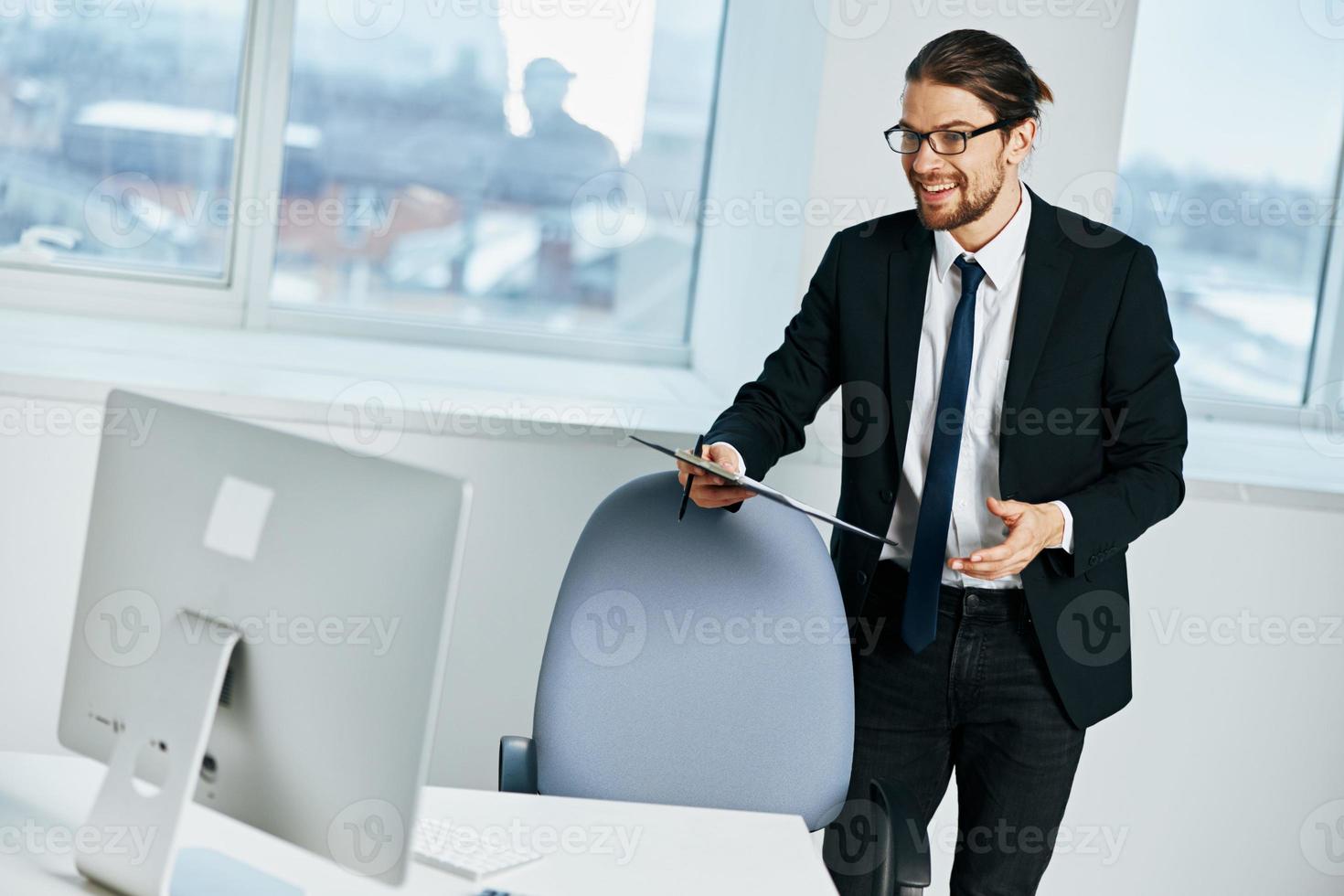 male manager sitting at a desk in front of a computer technologies photo