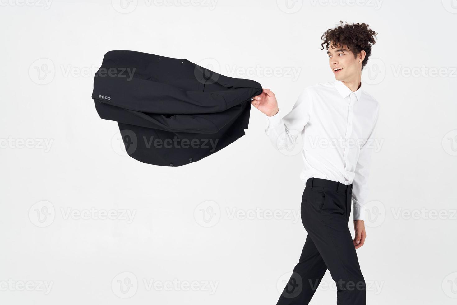 guy in a shirt and trousers with a jacket in his hand on a light background cropped view model photo