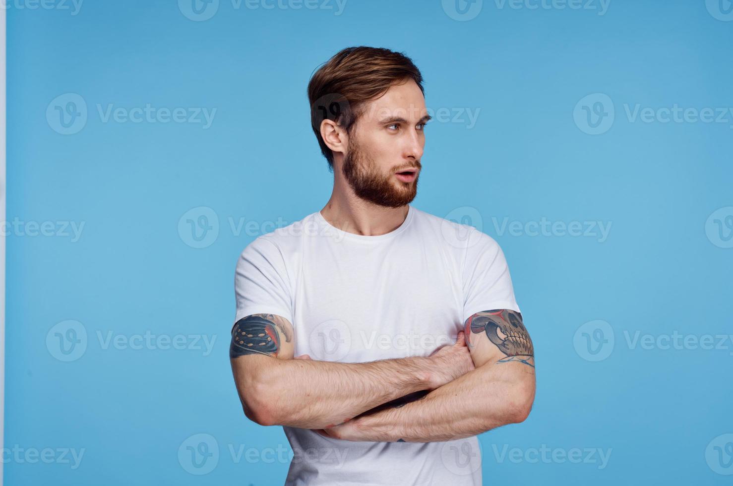 alegre hombre en blanco camiseta tatuaje en su brazos recortado ver Moda foto