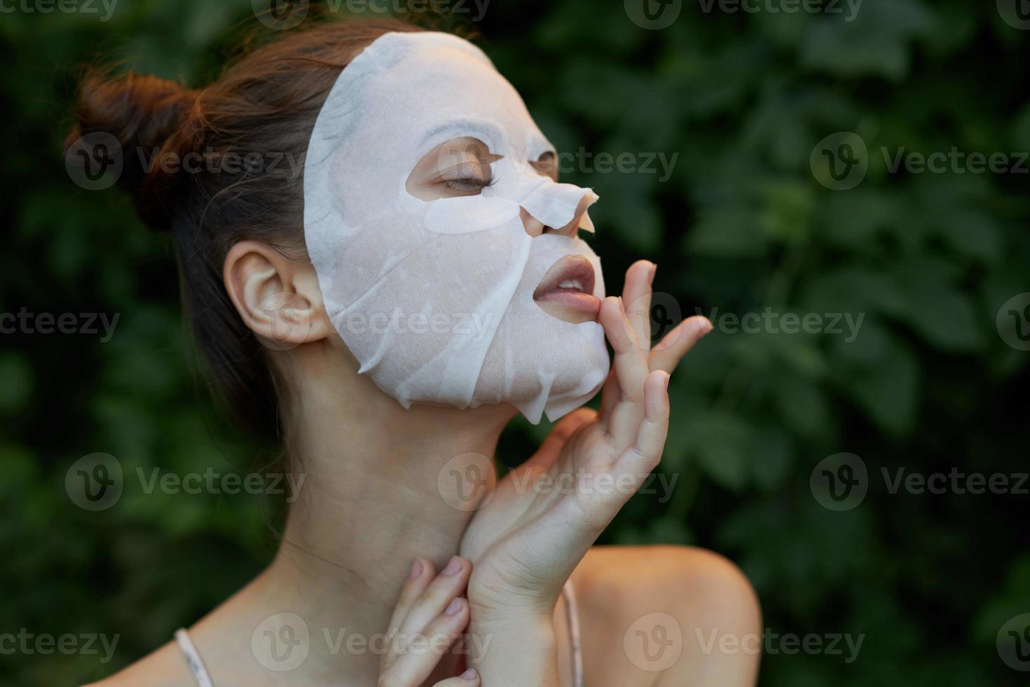 Nice woman anti-aging mask Touching his face with his hand side view skin photo
