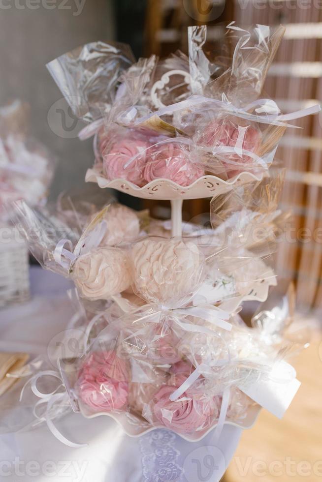 Homemade marshmallows on a three-tiered bookcase at a sweet bar at a wedding or party photo
