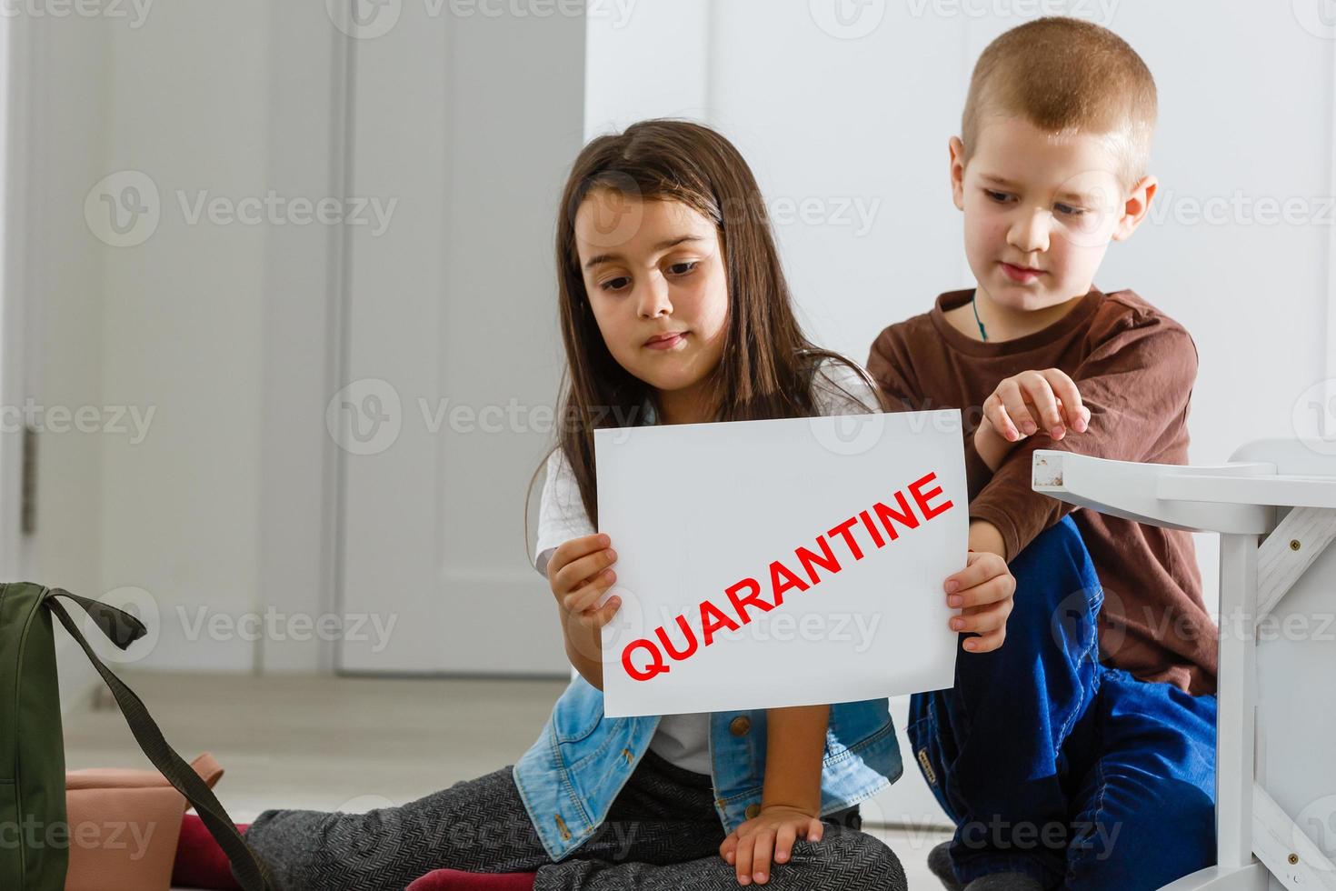 two children are sitting in a room, red inscription quarantine, concept of quarantine measures during the period of the disease epidemic photo