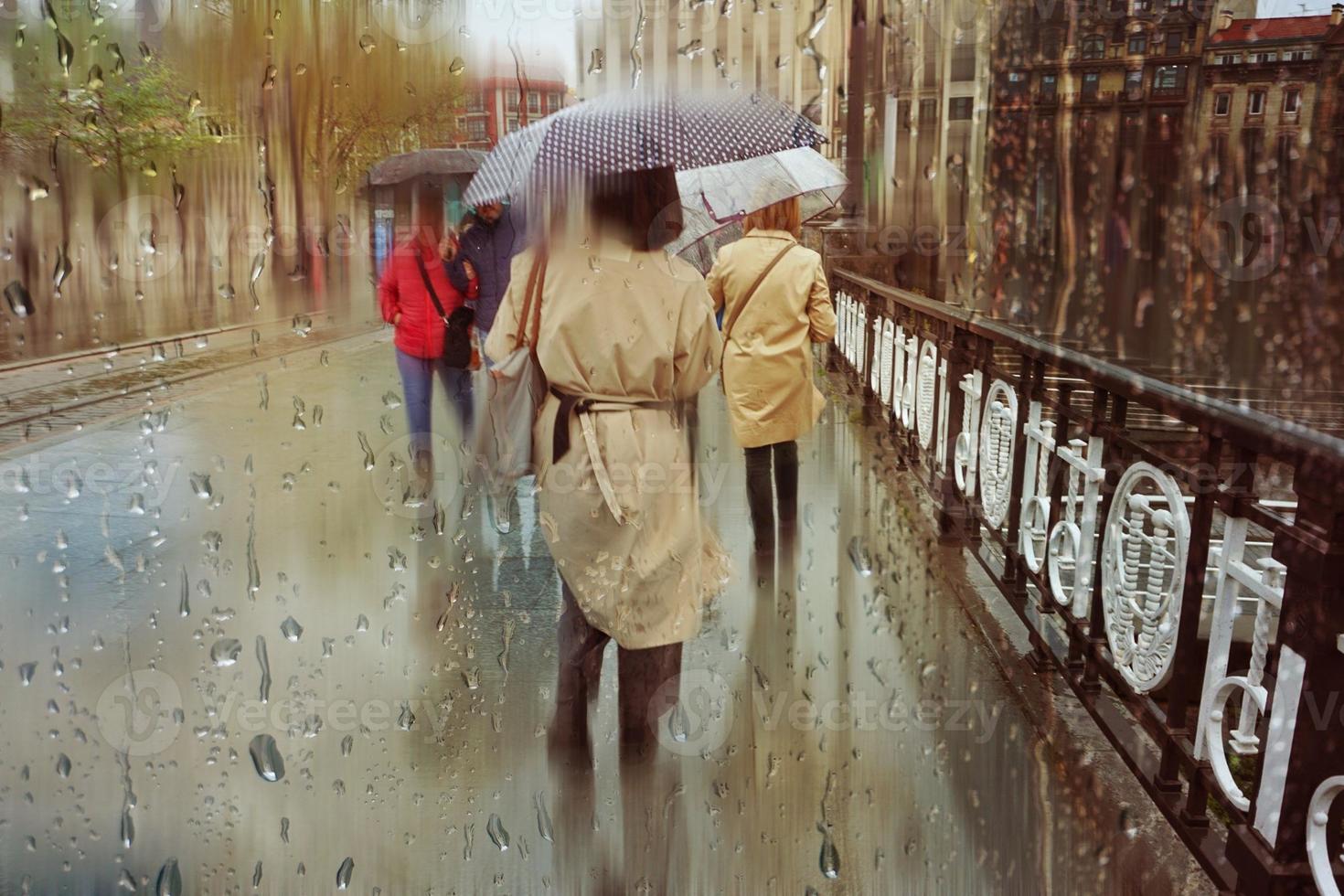 people with an umbrella in rainy days in winter season, bilbao, basque country, spain photo