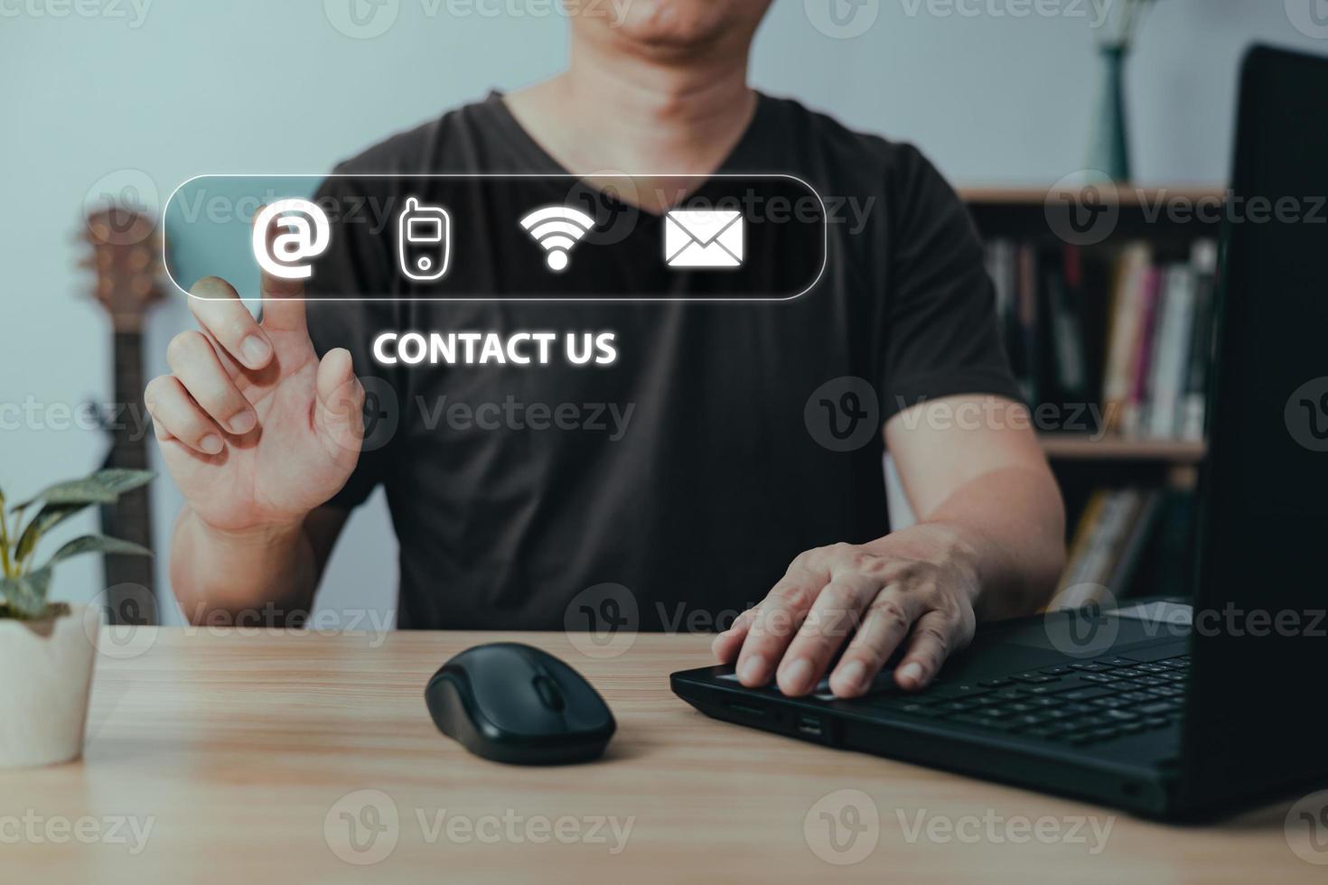 Businessman using laptop computer and touch on virtual screen contact icons address,phone,wifi,email,Contact us and Customer support hotline people connect. photo