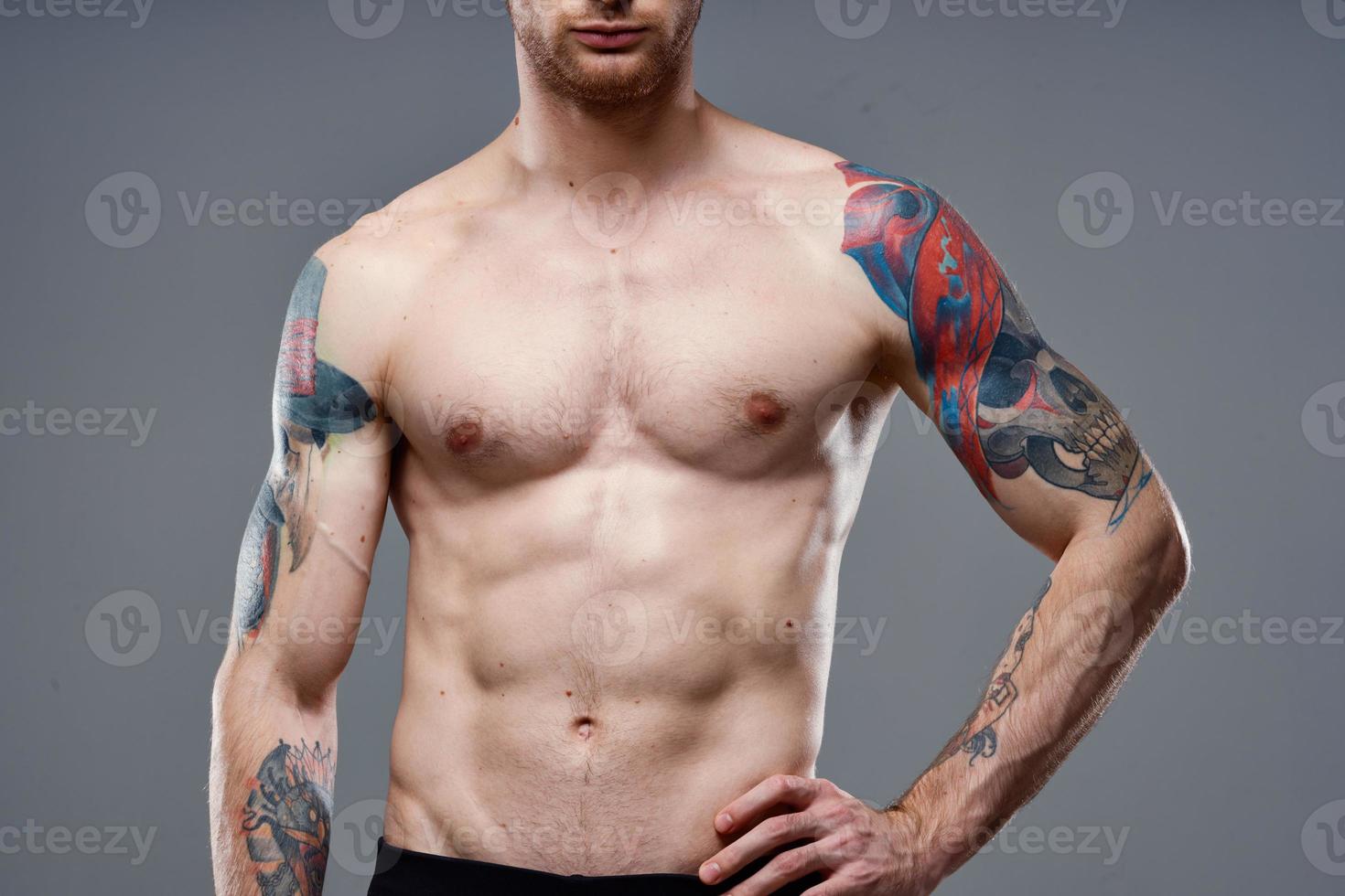 sporty man with a pumped-up torso tattoo on his arms cropped view model photo