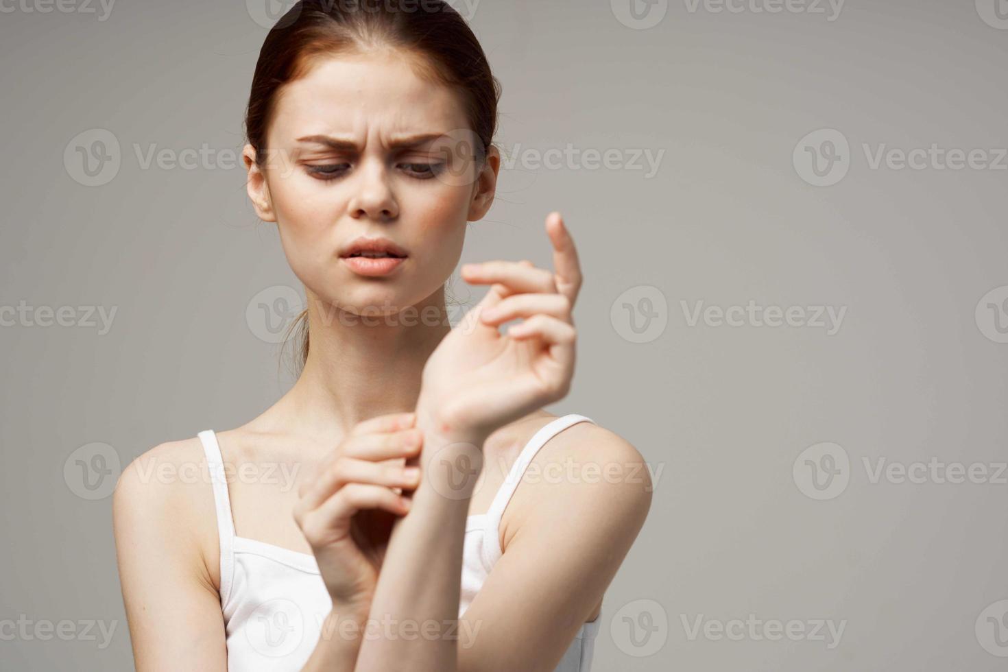 woman in white t-shirt rheumatism arm pain health problems isolated background photo