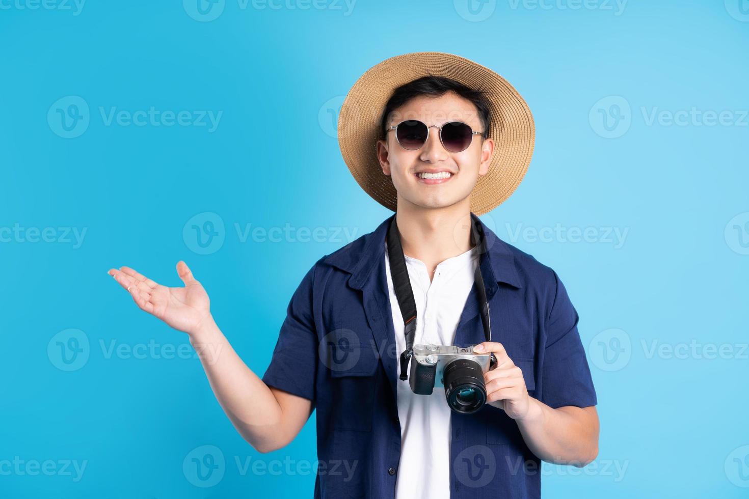 travel asian man portrait, isolated on blue background photo