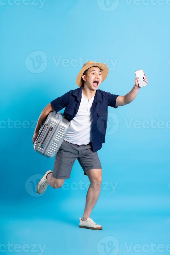 travel asian man portrait, isolated on blue background photo