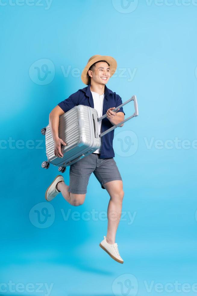 travel asian man portrait, isolated on blue background photo