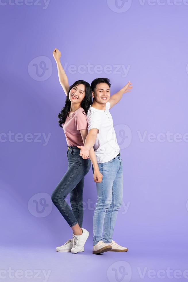 full body image of asian couple posing on purple background photo