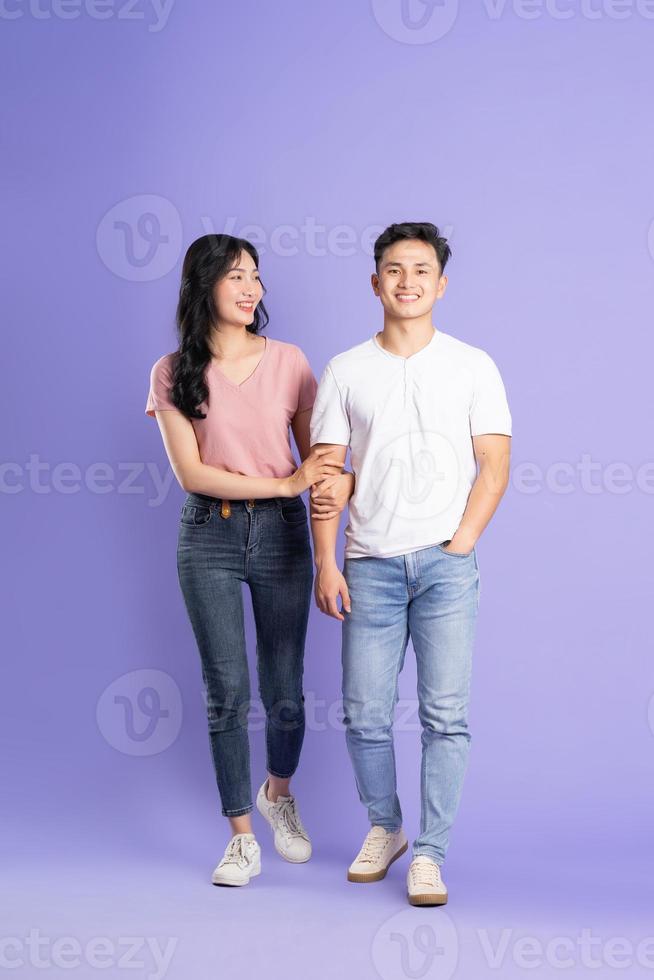 full body image of asian couple posing on purple background photo
