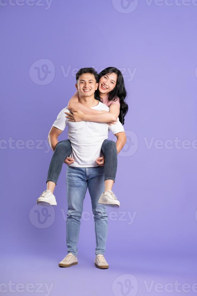 full body image of asian couple posing on purple background photo