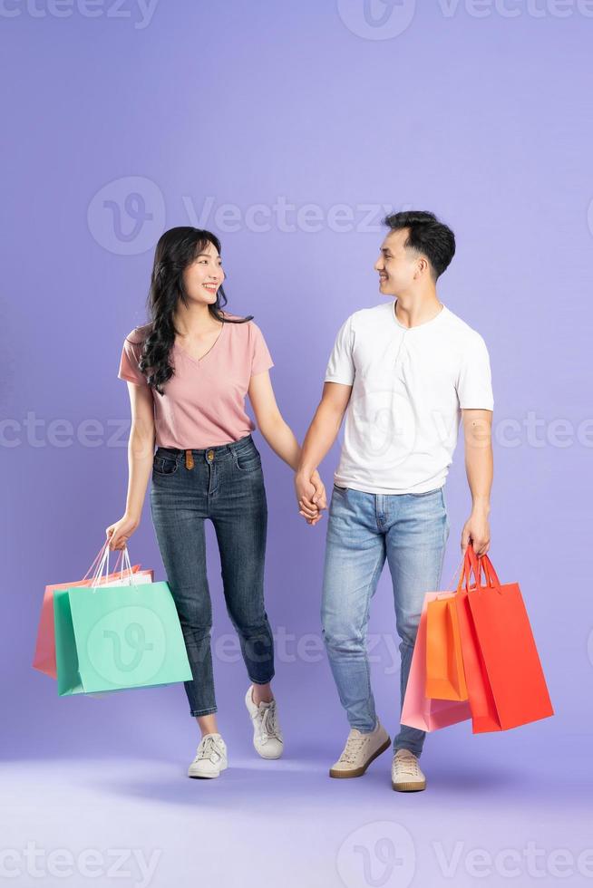 imagen de asiático Pareja participación compras pantalones en púrpura antecedentes foto