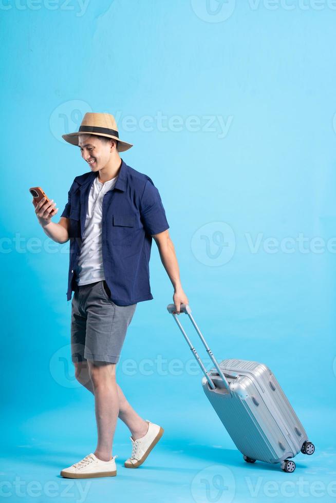 travel asian man portrait, isolated on blue background photo