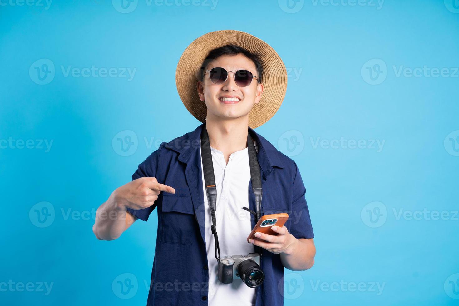 travel asian man portrait, isolated on blue background photo