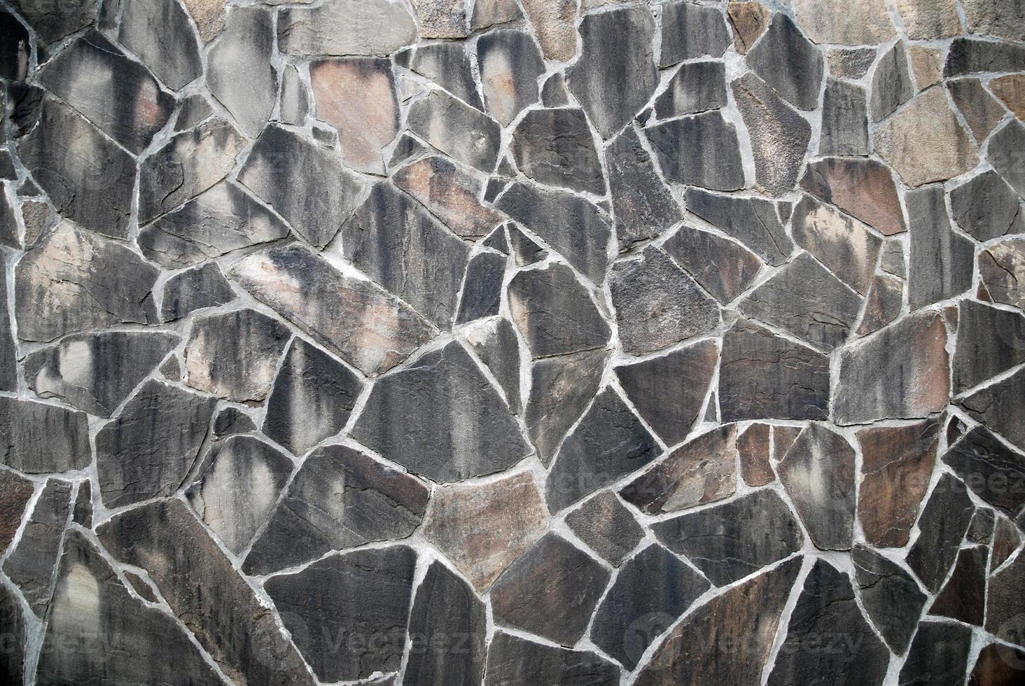 Slate stone texture, natural mudstone wall of irregular polygons in gray brown color photo