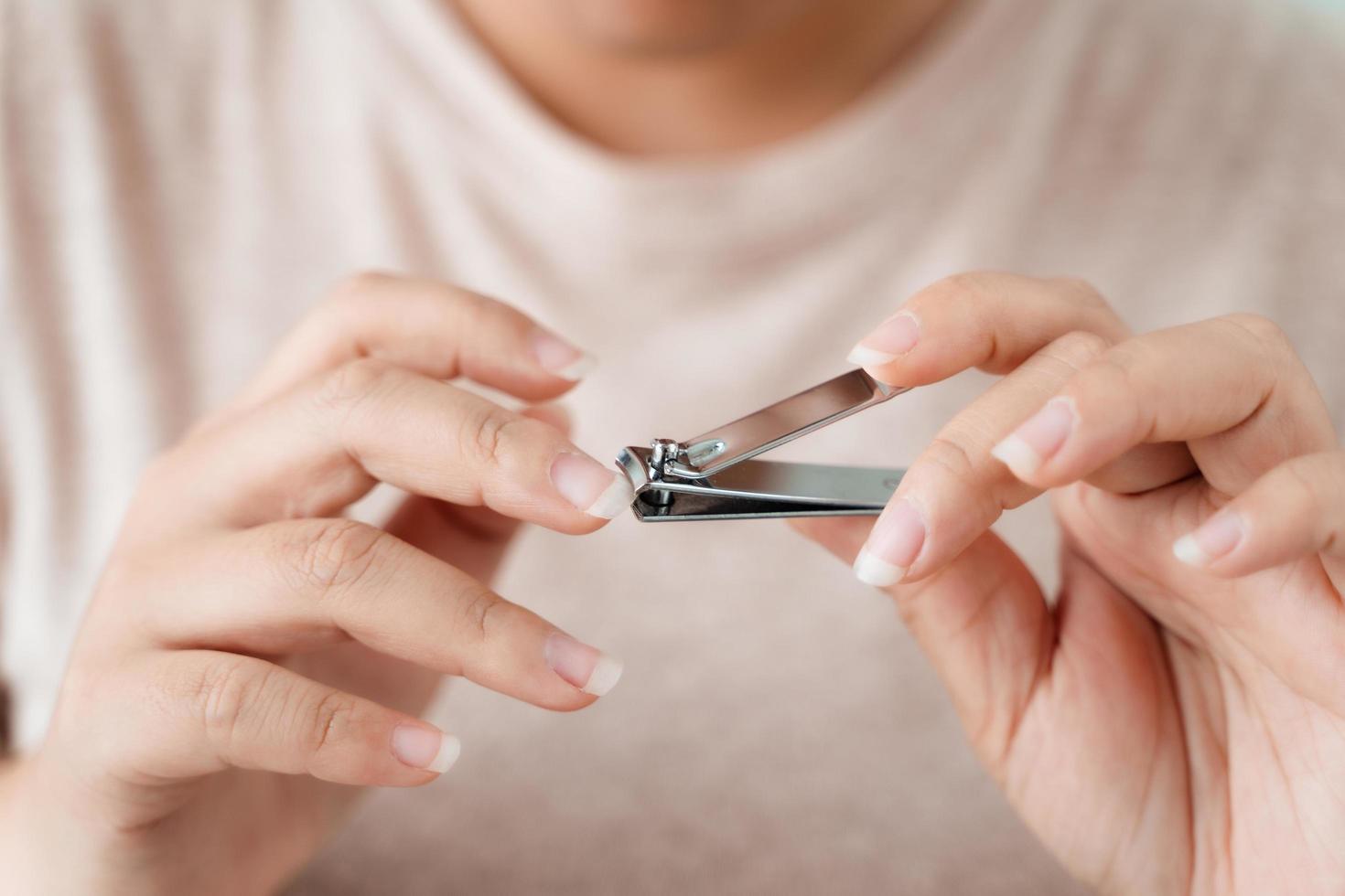 mujer corte las uñas utilizando uña clíper, cuidado de la salud, belleza concepto. foto