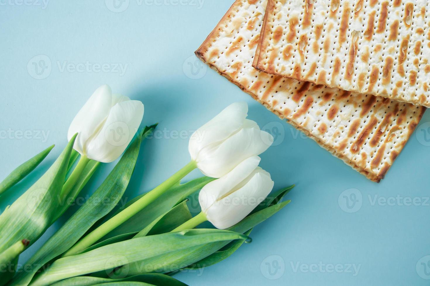 Matzo and white tulips on a blue background. Religious Jewish holiday Pesach. Happy Passover concept. photo