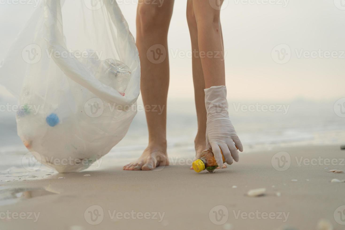 ahorrar agua. los voluntarios recogen basura en la playa y las botellas de plástico son difíciles de descomponer para evitar dañar la vida acuática. tierra, ambiente, planeta verde, reducir el calentamiento global, salvar el mundo foto