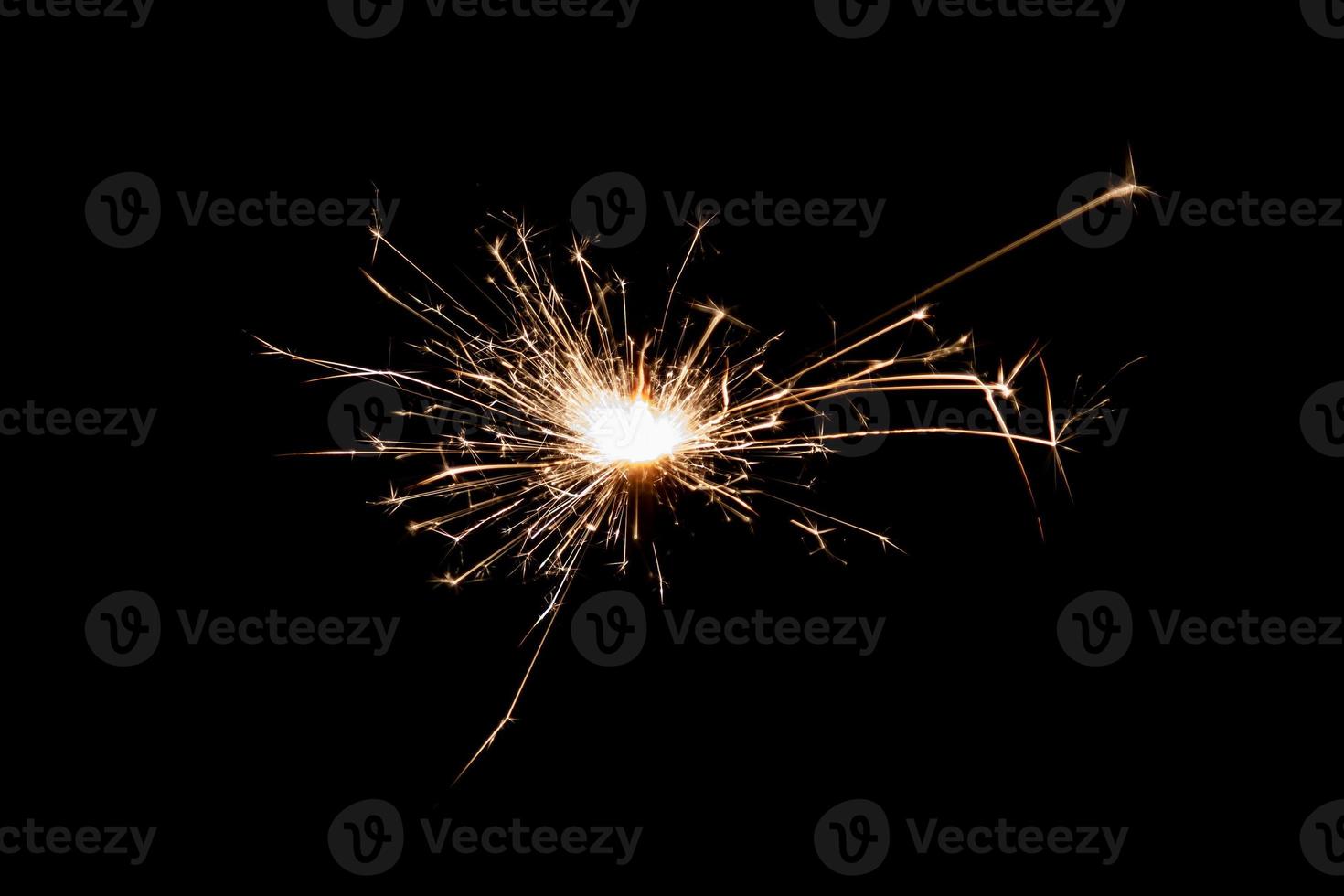 Burning sparkler isolated on black background. Fireworks theme. Light effect and texture. photo