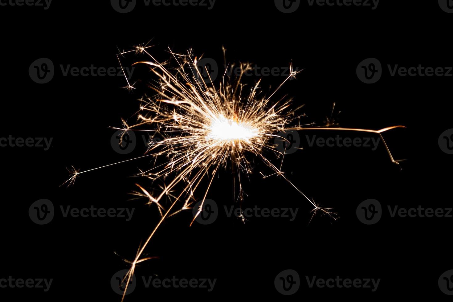 Burning sparkler isolated on black background. Fireworks theme. Light effect and texture. photo