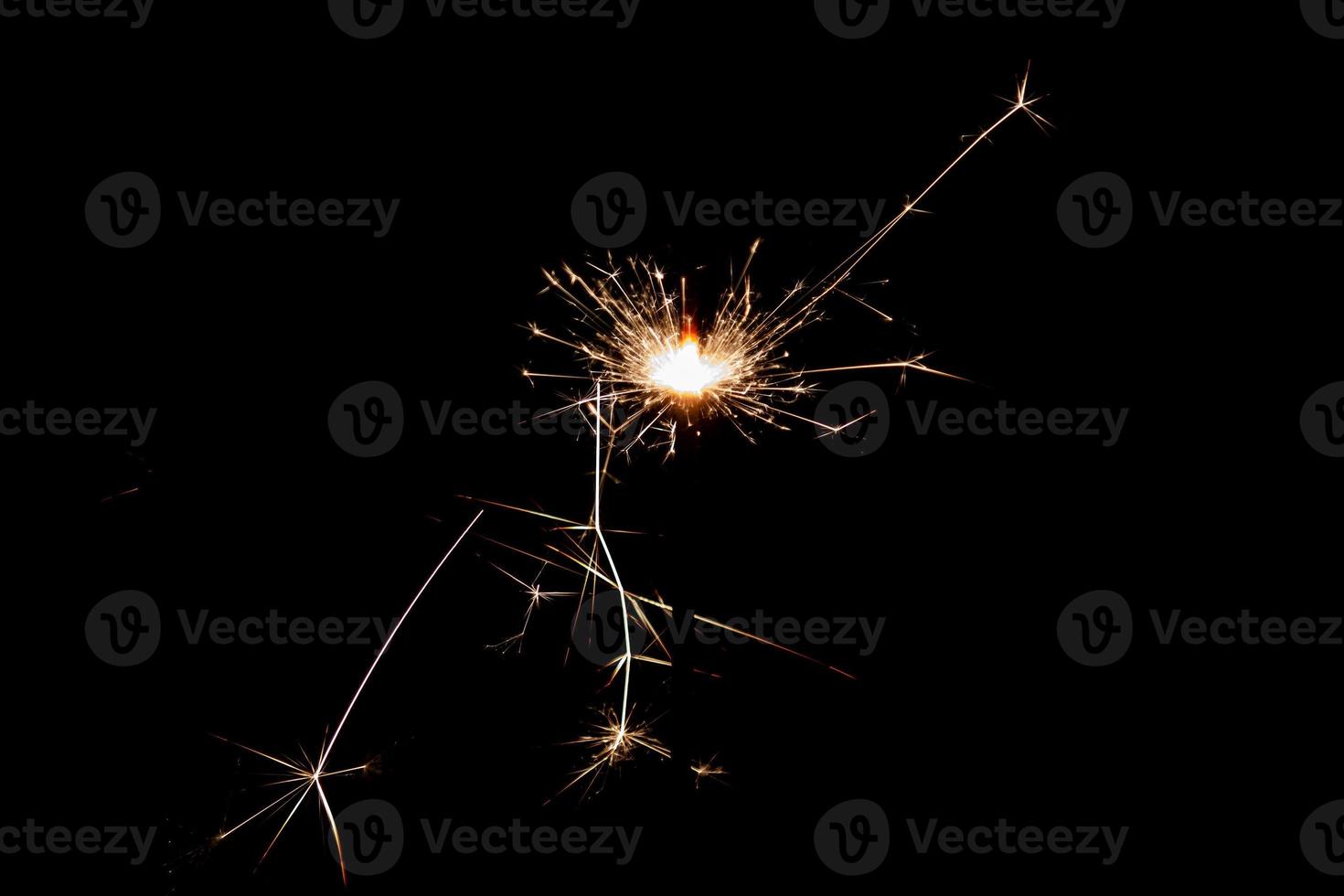 Burning sparkler isolated on black background. Fireworks theme. Light effect and texture. photo