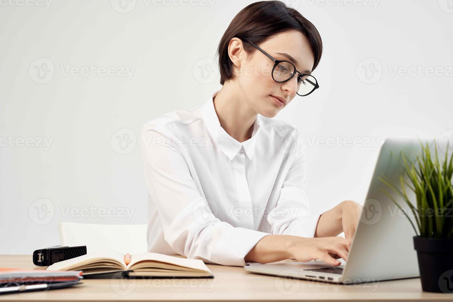 Businesswoman at the desk with glasses self-confidence light background photo