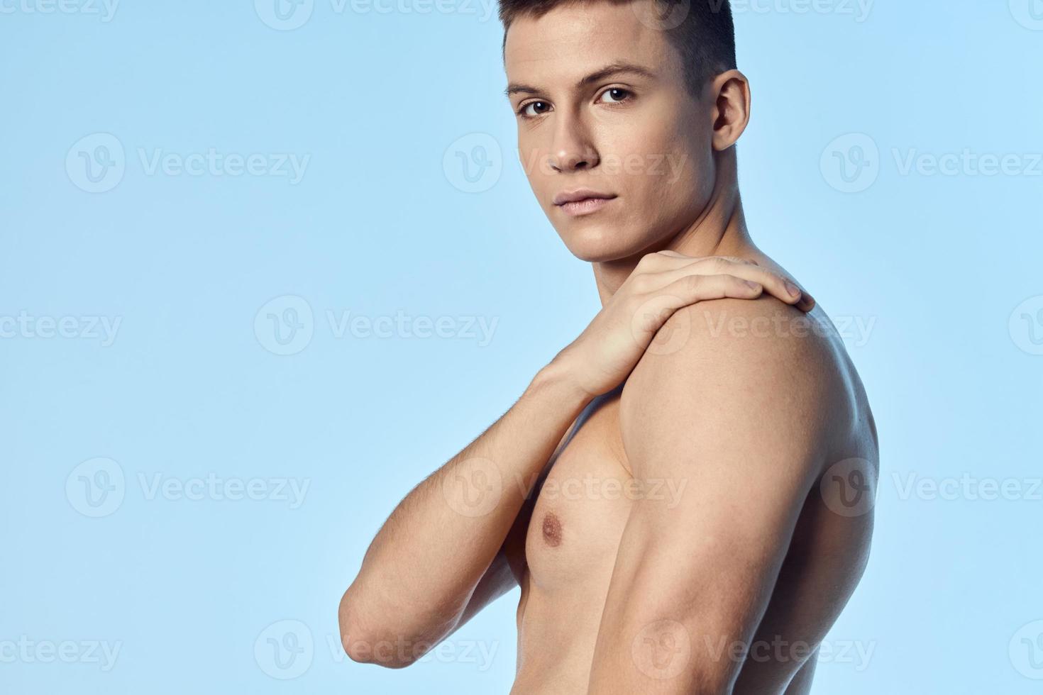 bodybuilder sporty man on blue background nude torso cropped view photo