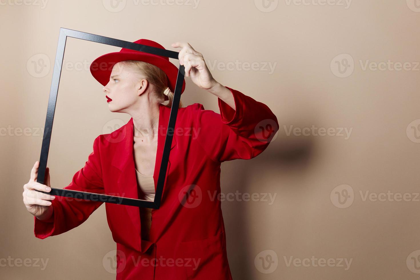 portrait of a woman with wooden frame posing red suit Lifestyle posing photo