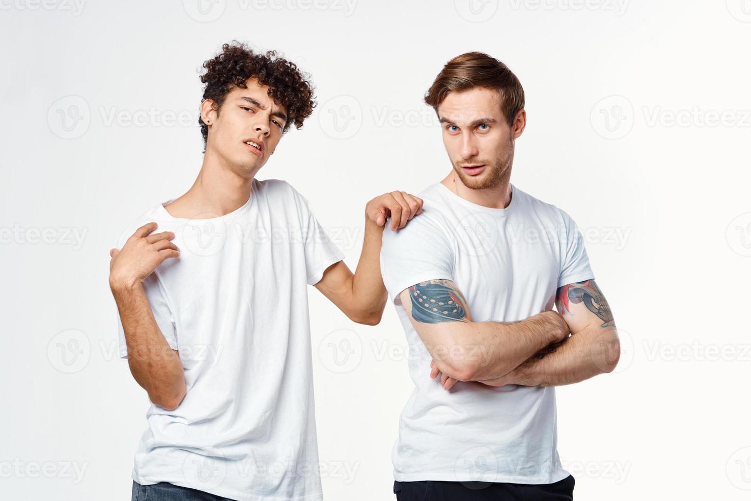 two men in white t-shirts are standing side by side isolated background photo