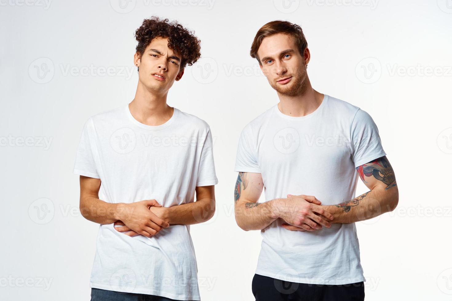 dos gracioso amigos en blanco camisetas riendo positivo emociones foto
