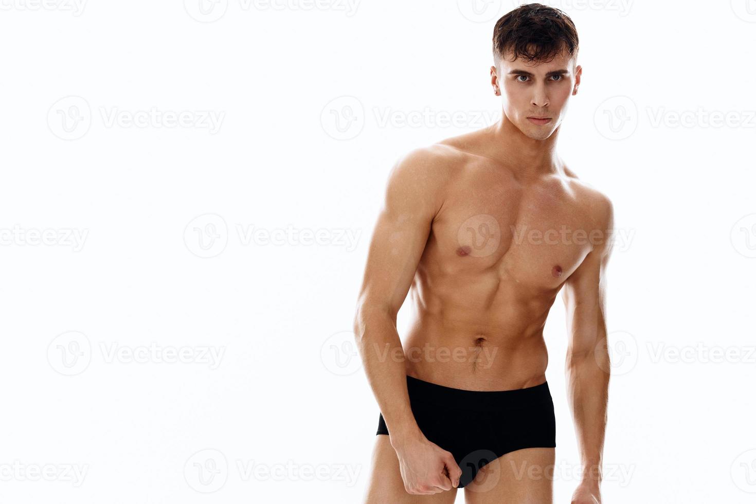 sports man bodybuilder posing model muscles light background photo