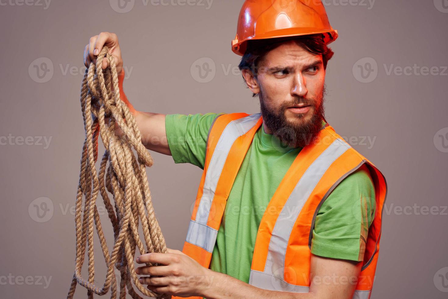 Man in construction uniform orange hard hat cropped view over beige background photo