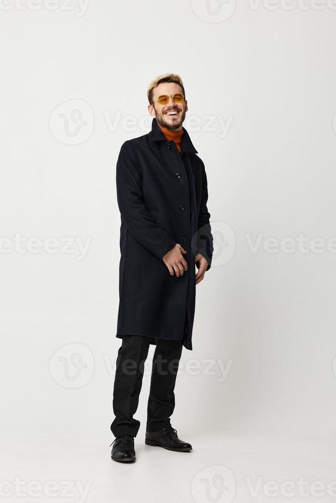 male model in a black coat and pants boots light background pose Copy Space photo