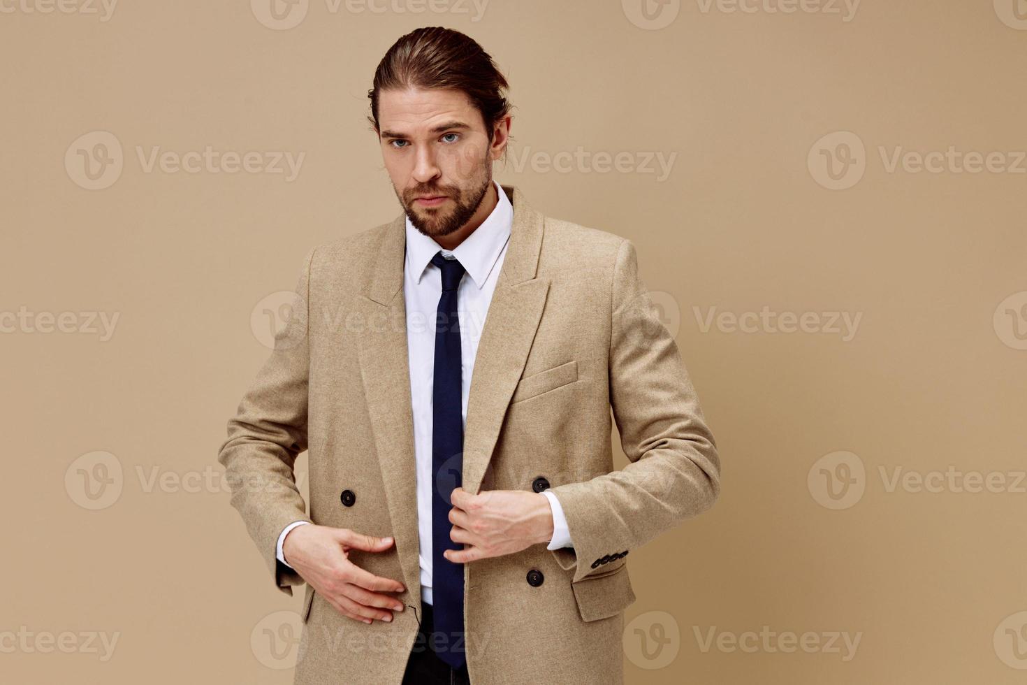 man in beige jacket in a suit with a tie posing isolated background photo