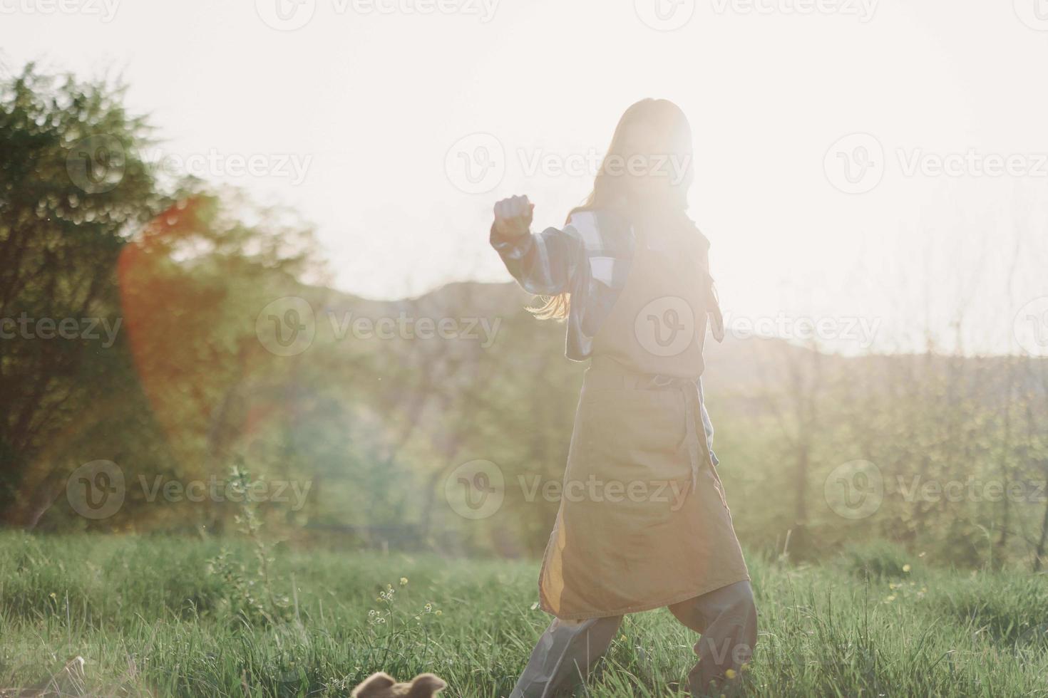 un mujer corriendo mediante un campo en un verano día con largo fluido pelo en el rayos de el ajuste Dom. el concepto de libertad y armonía con naturaleza foto