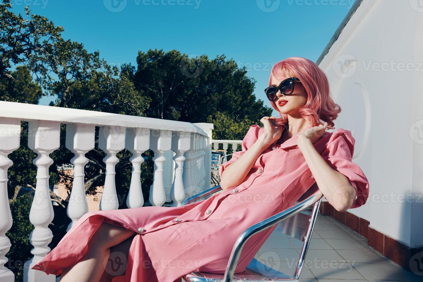 glamorous woman with pink hair wearing sunglasses posing sunny day photo