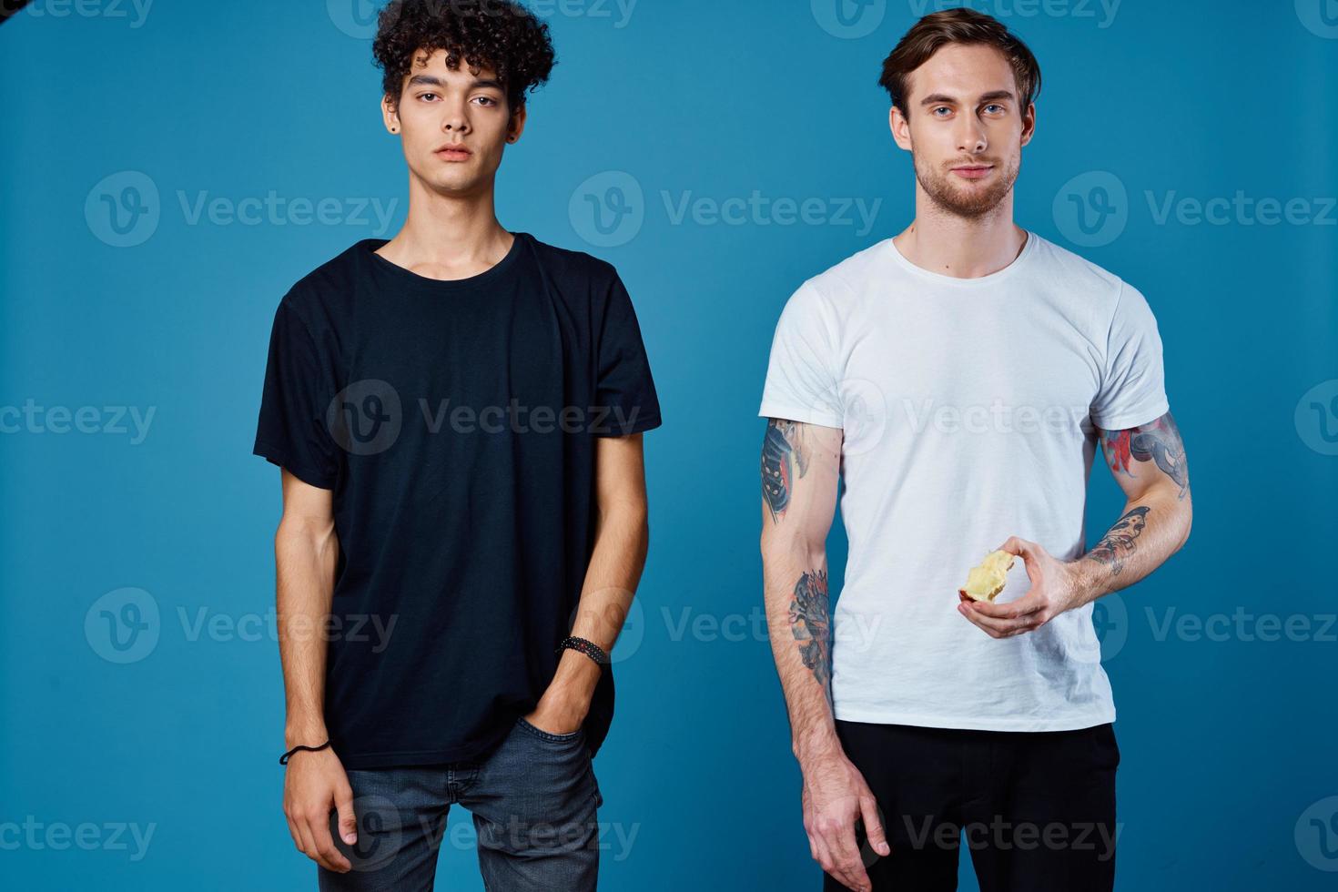 two men in t-shirts on a blue background and pants chatting friends photo