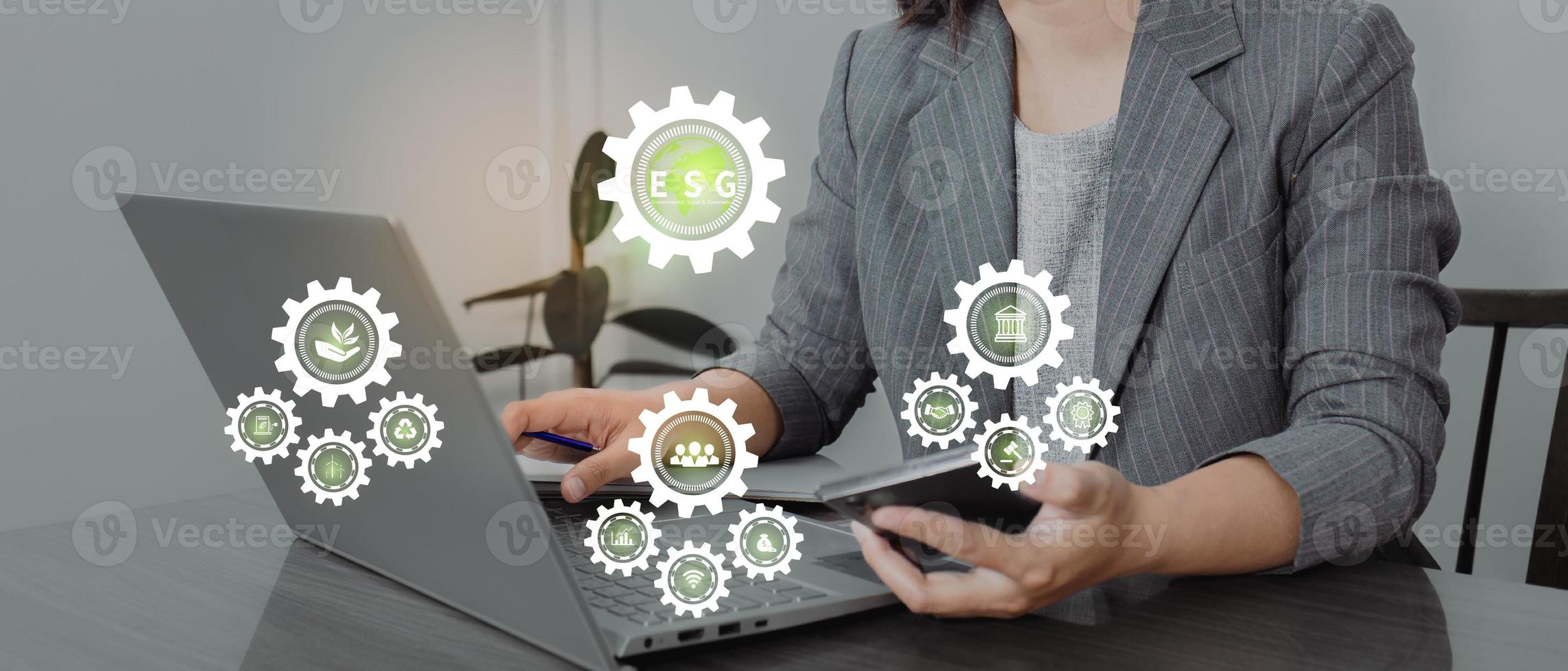 ESG environment social governance investment business concept. Women use a computer to analyze ESG, surrounded by ESG icons .close to the computer screen in business investment strategy concept. photo