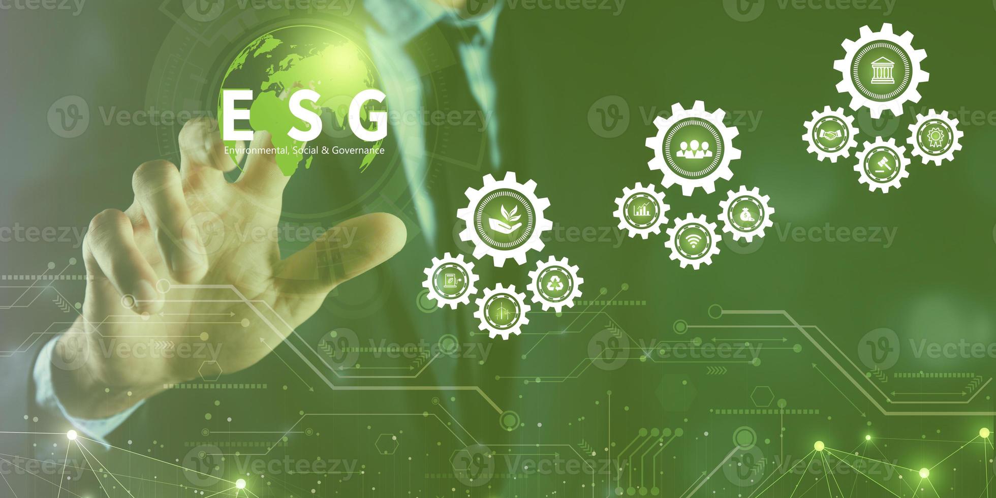 Businessman touching ESG icon on virtual screen for environmental, social, and governance in sustainable and ethical business on a technology green background photo