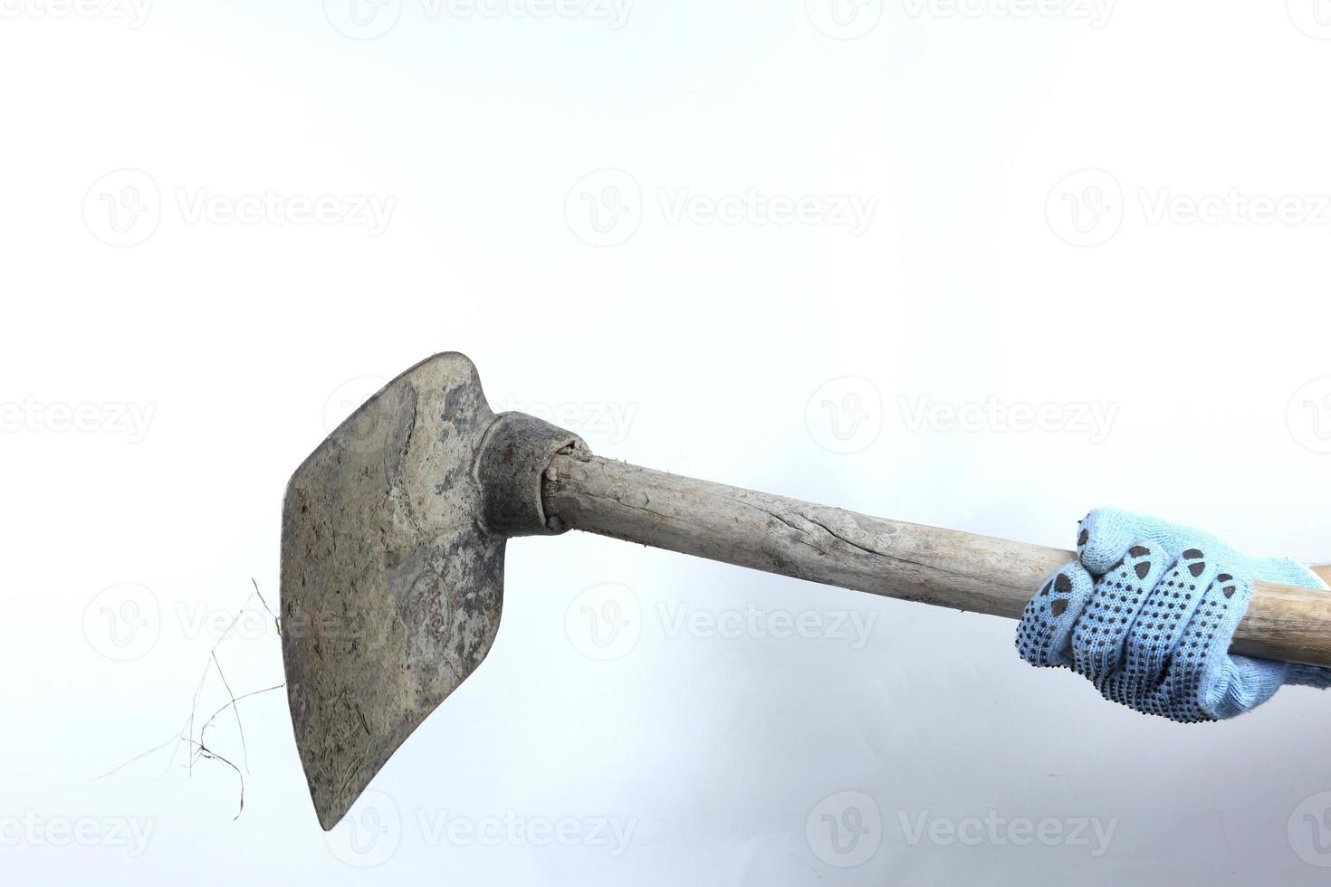 Gloved hand holding hoe isolated on white background photo