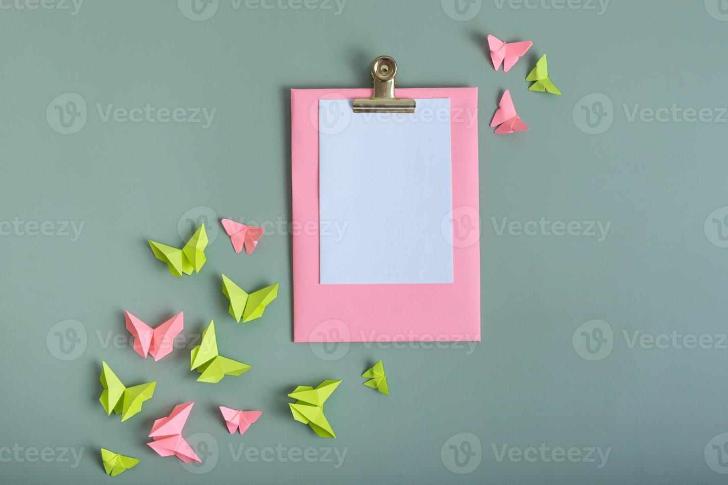Massage board mockup with paper butterflies green and pink color flat lay on a colored background photo