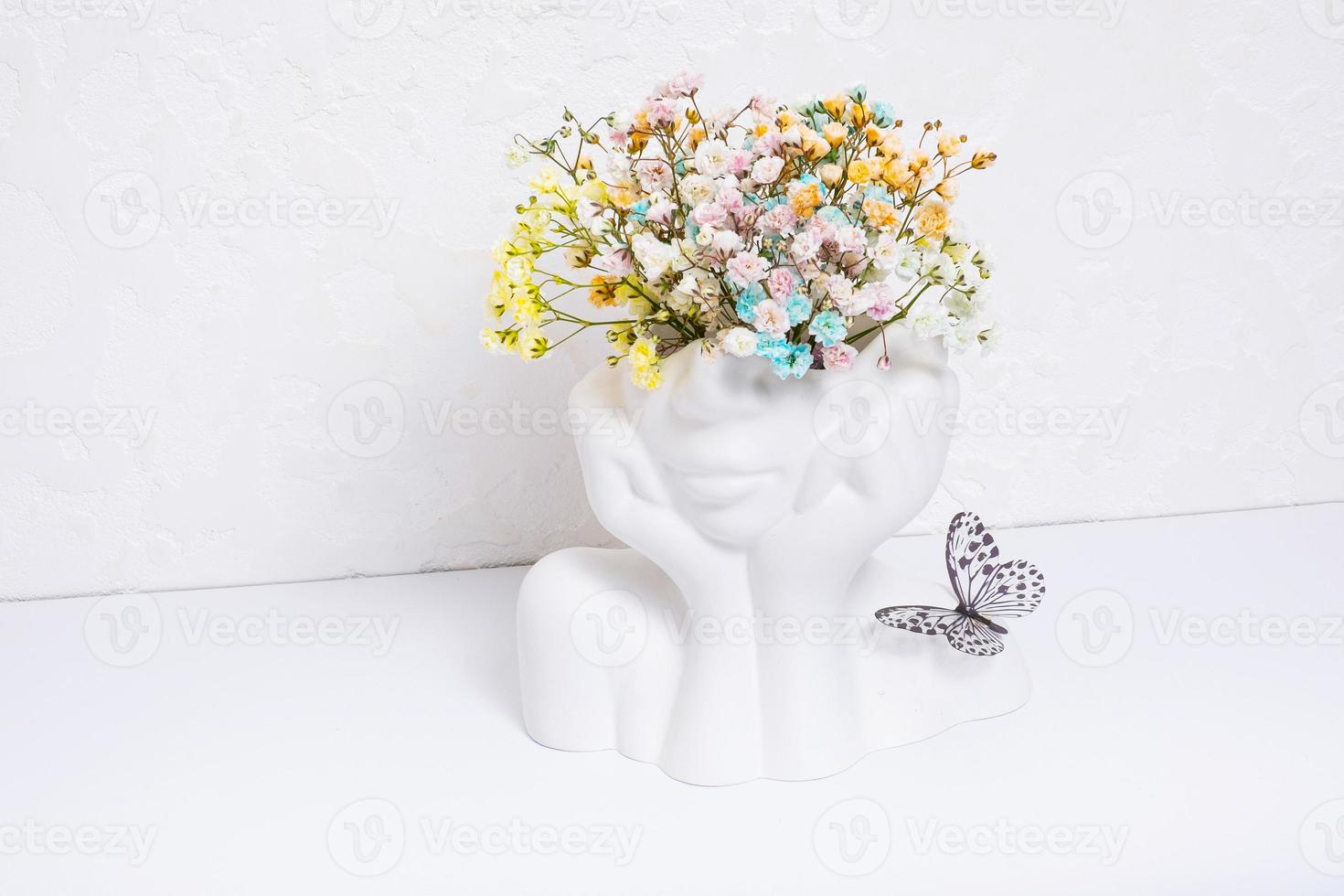 Mental health concept. Creative plaster vase head-shape with colorful flowers and butterfly photo