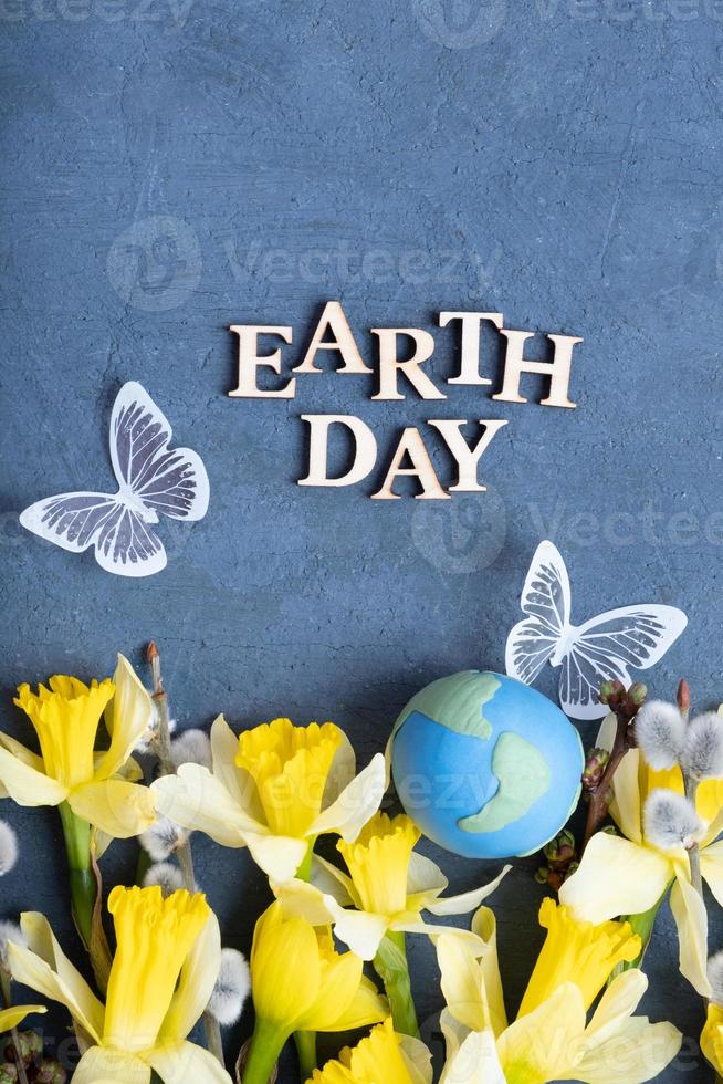 Earth day text with globe, flowers and butterfly. Happy Earth day concept flat lay, top view photo