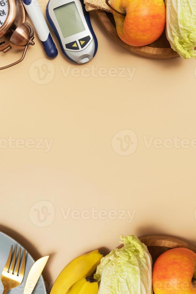 Glucose meter with cutlery and alarm clock on beige background with copy space flat lay, top view photo
