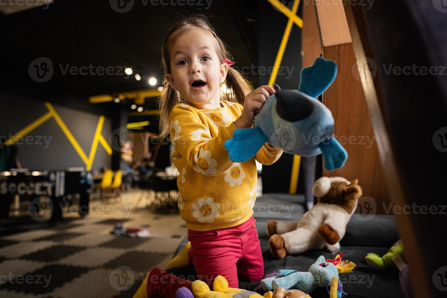 Baby girl playing with soft toys at modern kindergarten. photo