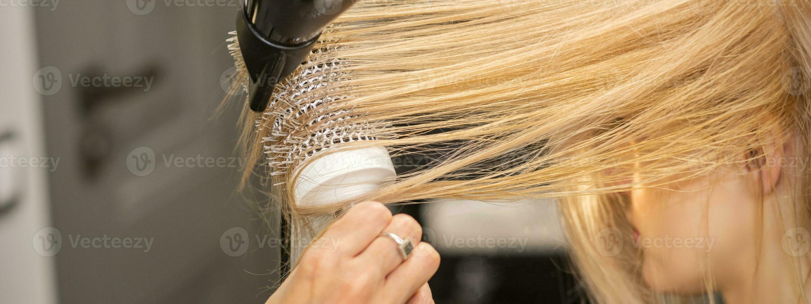 Hand drying hair of woman photo