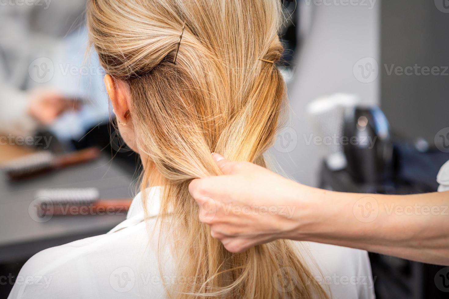 Hairdresser styling hair of woman photo