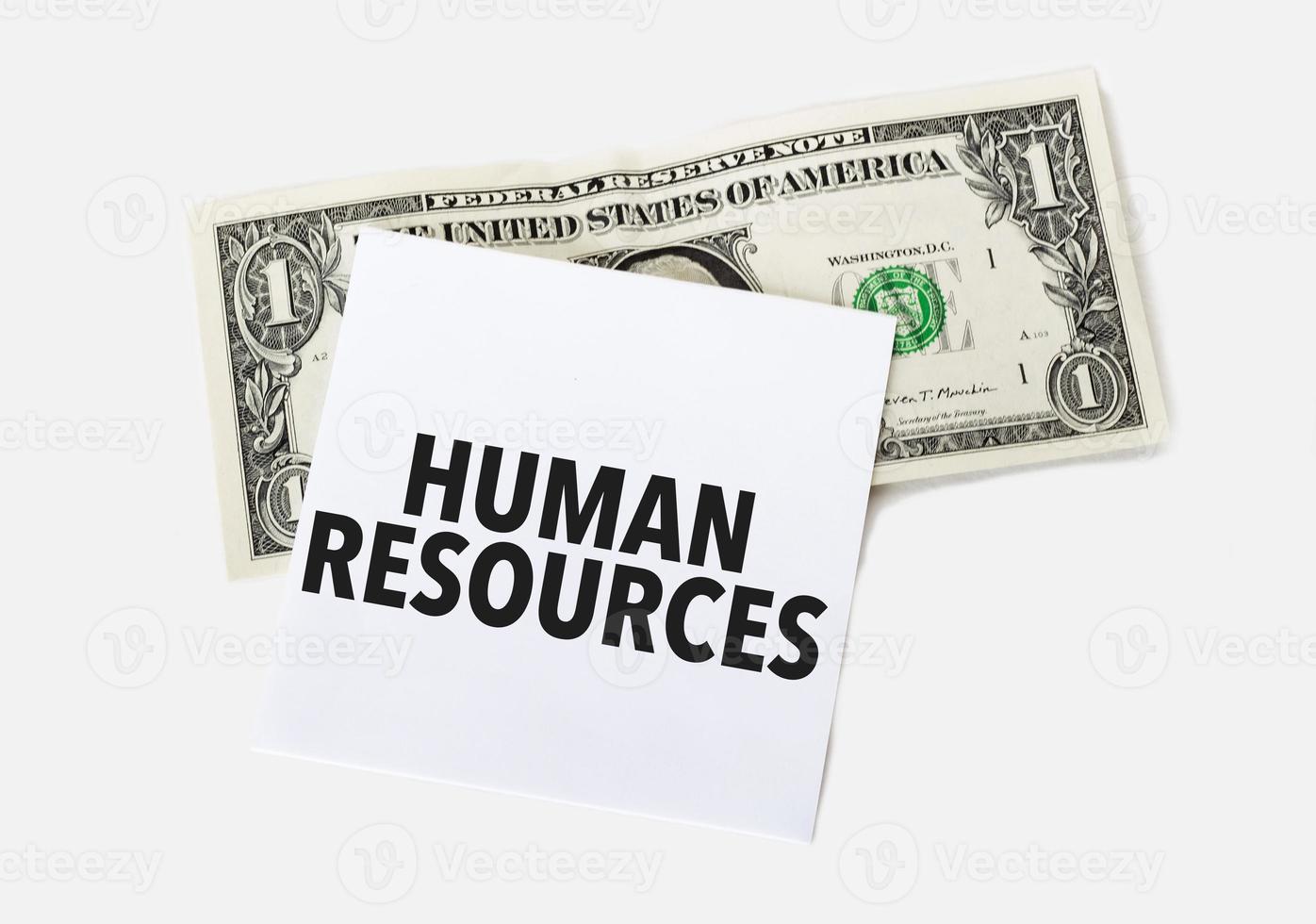 1 dollar bill and white notepad sheet on the white background. Text human resources photo